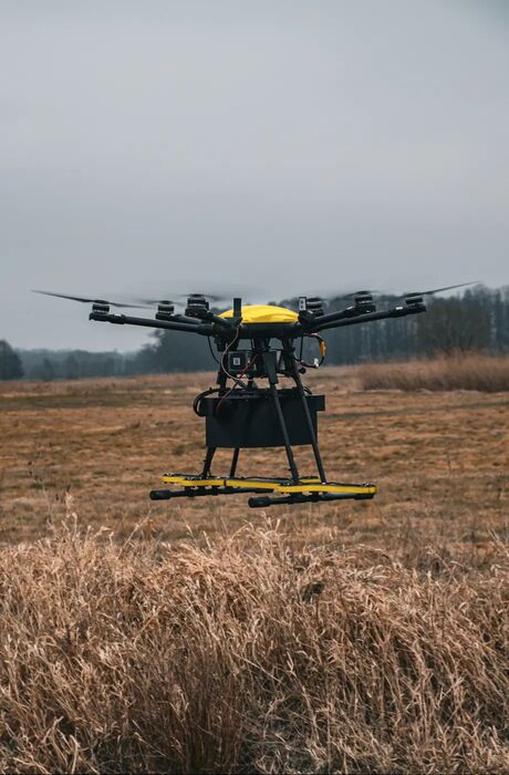The inspection drone hovers over a brown winter field.