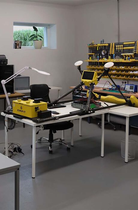 inside the hardware working garage a female coworker inspect the devices, our current mapper lays on the table