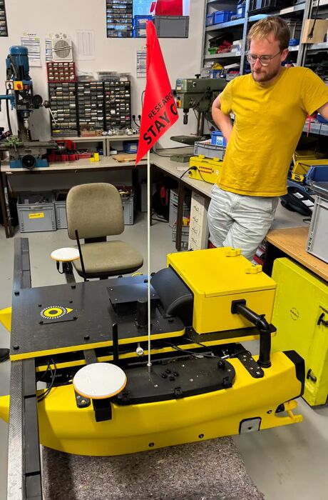 The inspection boat is on teh desk in the hardware workshop with an employer listening to a colleague.