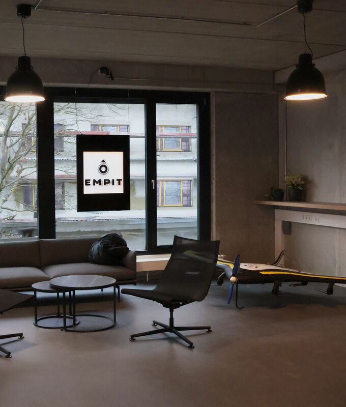 Employee stands outdoors in front of the building complex in Hamburg, holding the inspection drone in the complexe's courtyard.