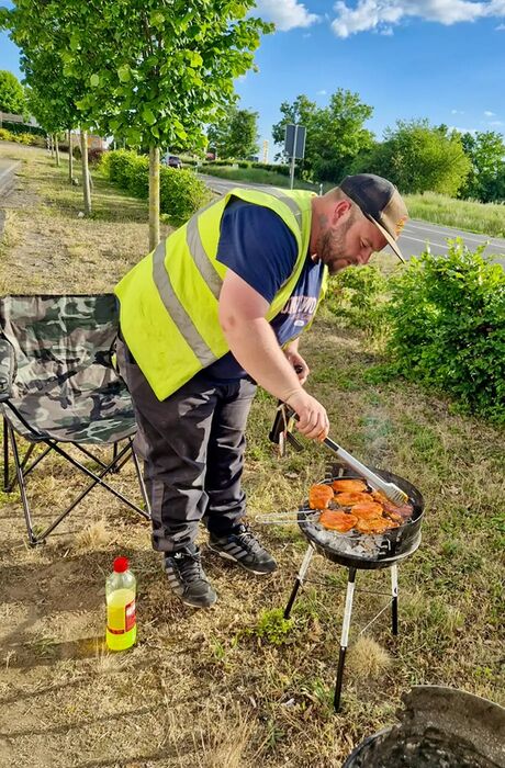 An EMPIT field operator grills at a barbecue.