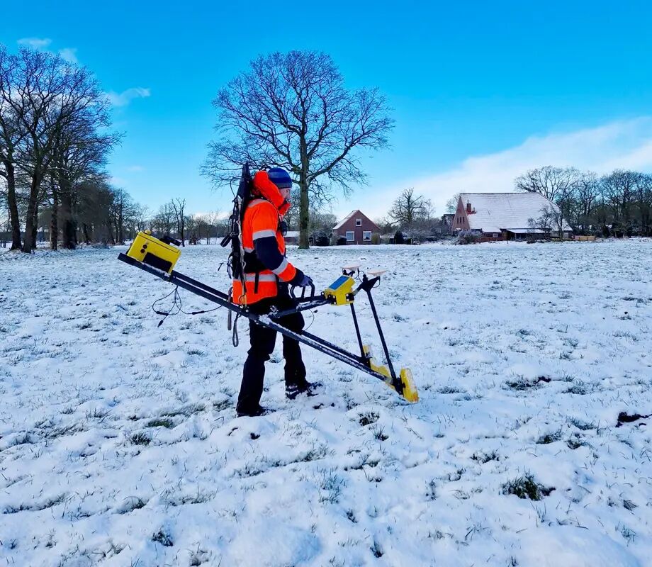 An operator is inspecting a burried pipeline running beneath a snowy field