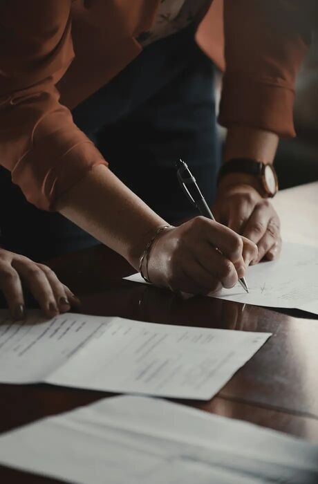 Close-up of a person signing certificates.